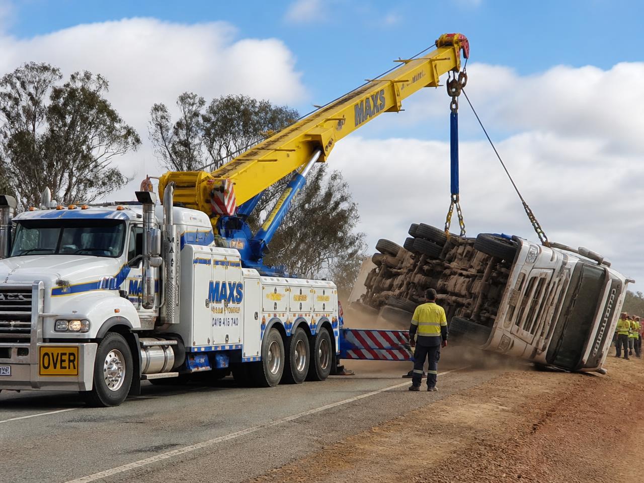 Heavy recovery truck uprighting an overturned semi-trailer on an Australian roadside